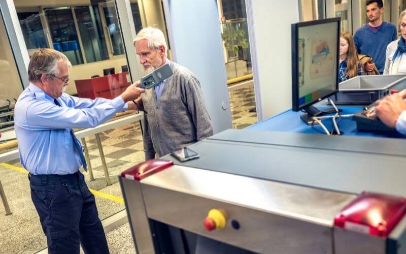 Security checking a guest using a metal detector