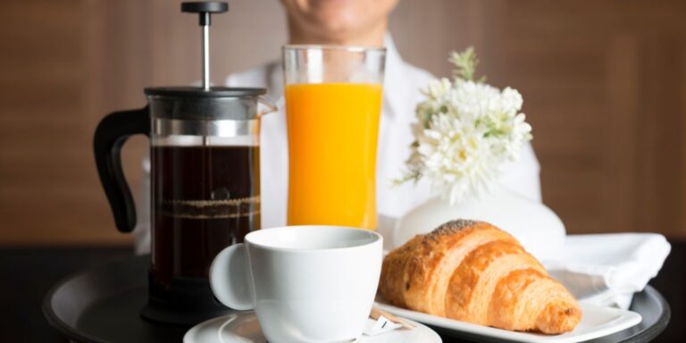 Room service, tray with coffee, juice and croissant