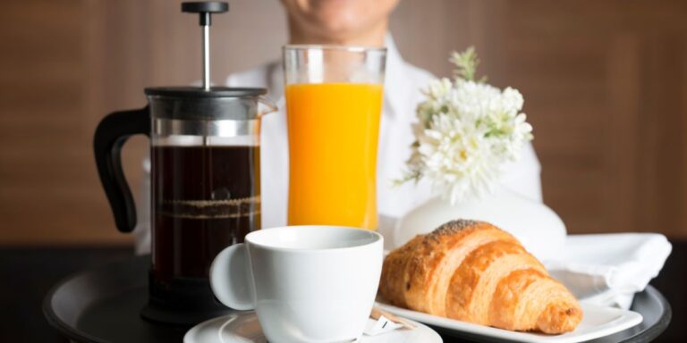 Room service, tray with coffee, juice and croissant
