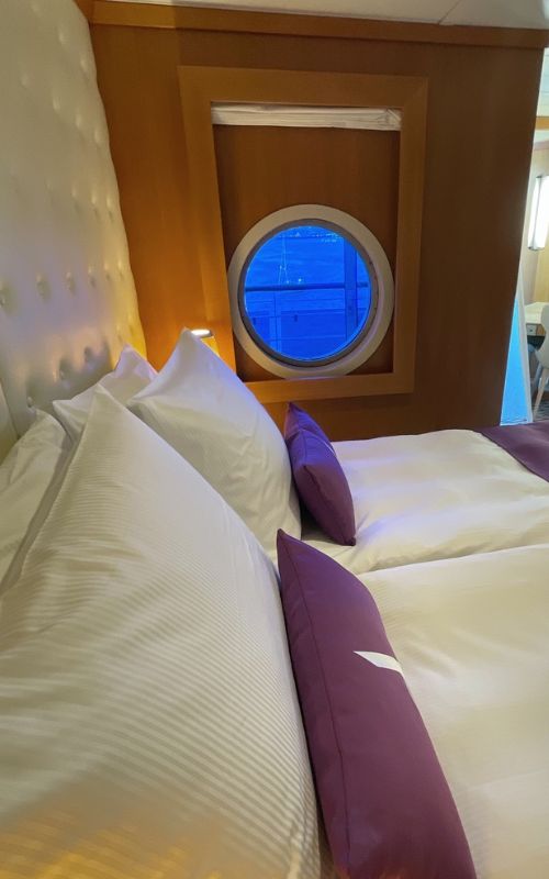 Room with a porthole on Ambition cruise ship