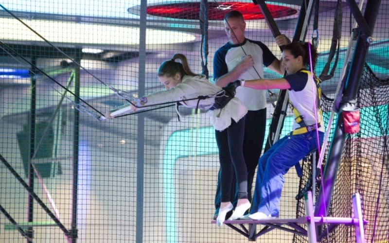 a girl learning how to do trapeze