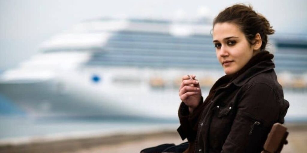 Girl smoking with cruise ship on background