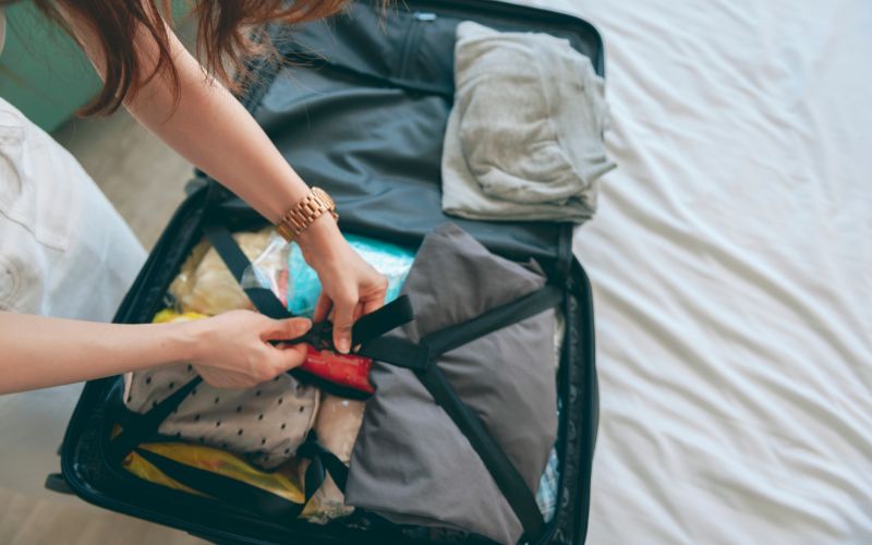 a woman unpacking a suitcase on an NCL cruise