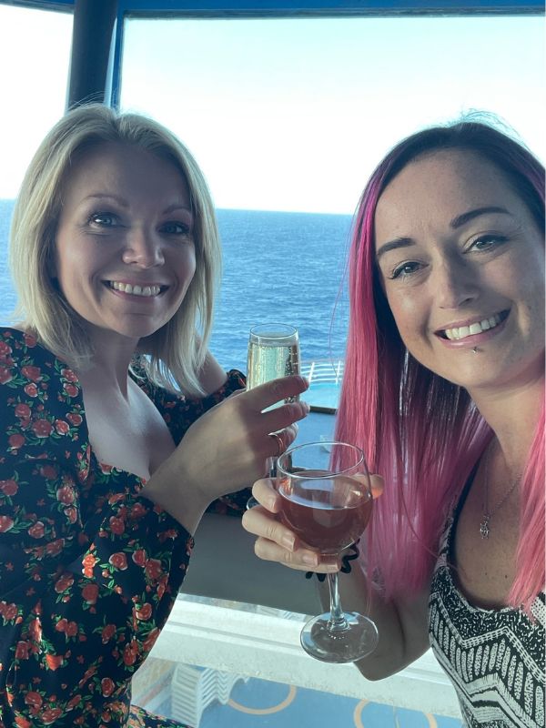 Two friends on a cruise enjoying a glass of champagne 